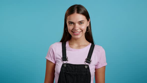 Young Smiling Woman with Long Hairstyle Looking To Camera. Portrait of Cute Beautiful Girl on Blue alt