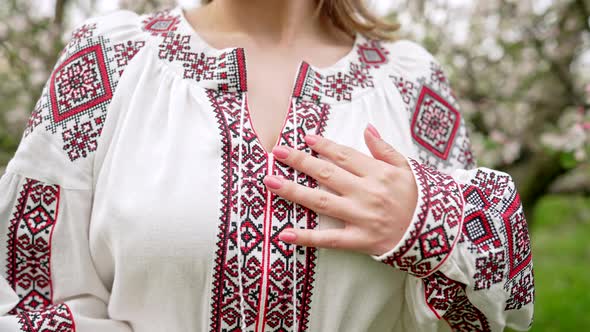 Woman Demonstrates Beautiful Details of Embroidery Ornament on Vyshyvanka Dress alt