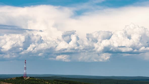 Movement of Cumulus Clouds Behind a Hill with a TV Tower on Top alt
