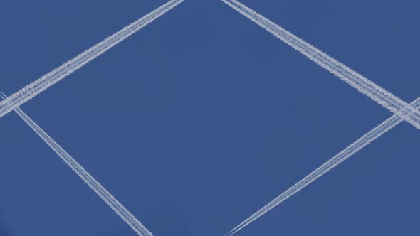 Airplanes Leaving White Traces on a Clear Blue Sky. Air Traffic. Place for Logo. alt