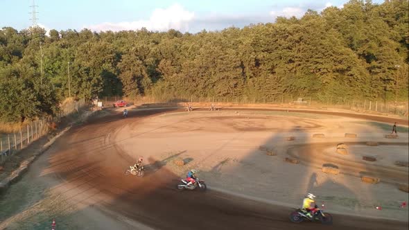 Motocross that drift on a curve of a dirt track circuit, high view alt