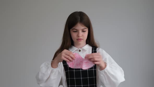 Little Young Girl Tears a Paper Heart Into Pieces