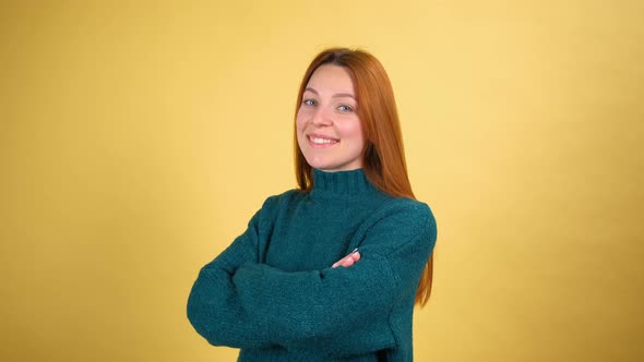 Studio Portrait of Confident Smiling Young Woman Laughing Against Yellow Background