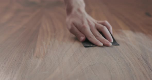Slow Motion Slide Orbit Shot of Man Hand Sanding Black Walnut Wood Table alt