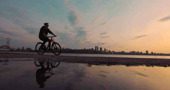 Silhouette of Bicyclist Riding Bike at Sunset Slow Motion alt