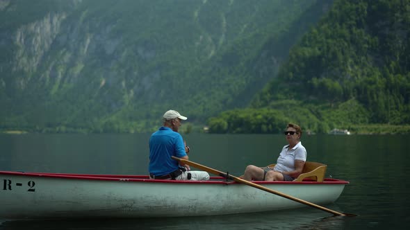 Active Seniors in Rowboat on Mountain Lake on Sightseeing Tour