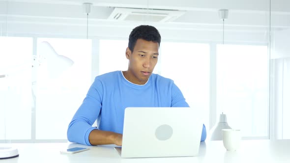 Afro-American Man Thinking and Working on Laptop alt