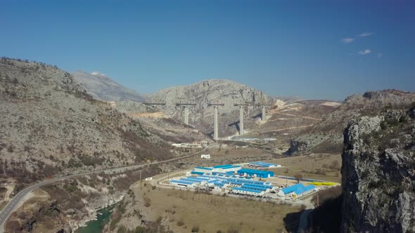 Aerial view of  Construction of bridge columns of a new highway through the Moraca canyon alt