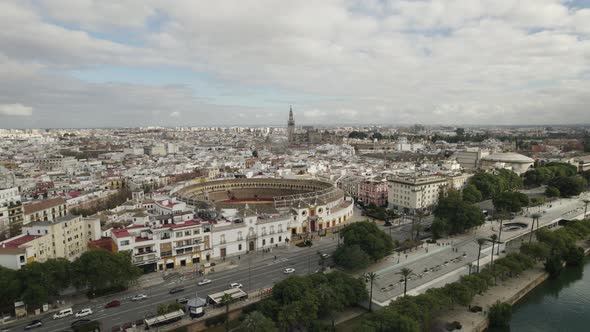 Maestranza bullring against Seville cityscape on cloudy day. Aerial view