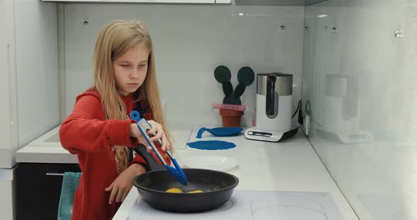 A Girl Cooks Food in the Kitchen