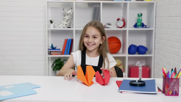 Glad Schoolgirl Having Fun Playing with Paper Plane at School Lesson in Classroom Positive Emotions alt