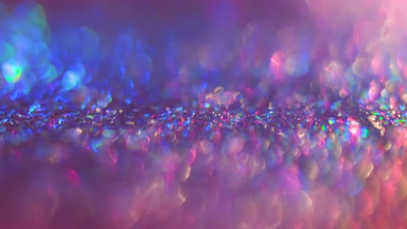 Colorful Spinning Glitters Rotating on the Background with Macro Bokeh Effect