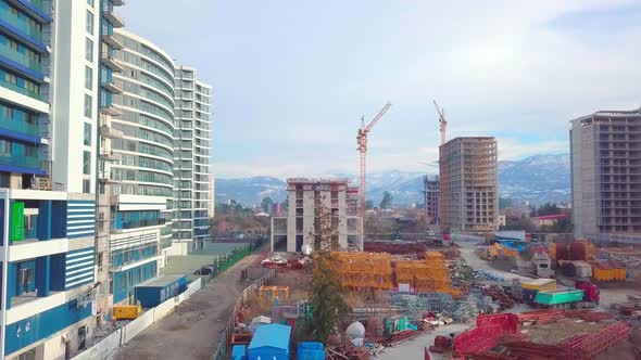 Drone view of construction of multi-storey buildings background of mountains. alt