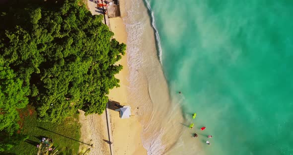 Bird's Eye View Of Waves And Sand Over A Cay With Turquoise Waters