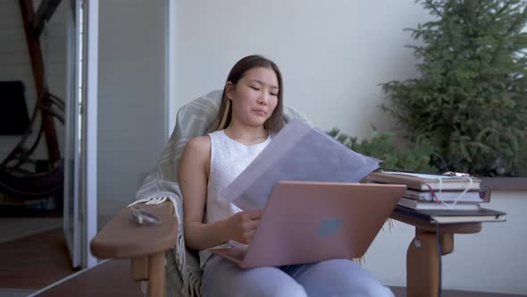 Unrecognizable Woman Passing Business Graphs to Thoughtful Concentrated Asian Lady Sitting with alt