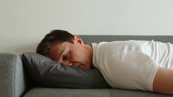 Portrait of young depressed man sleep and turn over on a pillow