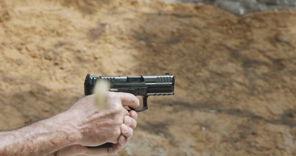 Pistol shooting bullets in slow motion footage. Hand guns in firing range alt