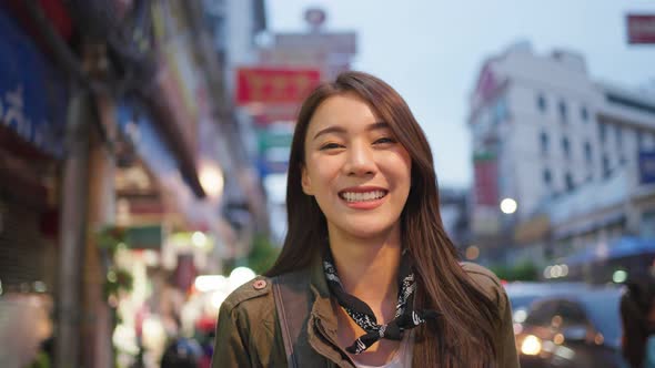 Portrait of Asian attractive woman backpacker travel in city at night. alt