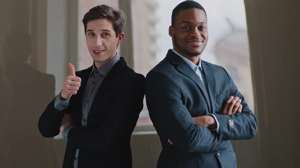 Two Multiracial Colleagues Posing in Office with Crossed Arms Caucasian Millennial Male Showing alt