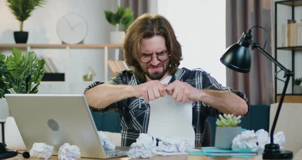 Office Worker in Glasses Sitting at His Workplace at Home, Working with Papers alt
