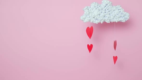 Paper Red Hearts Move in the Wind From a White Cloud on a Pink Background