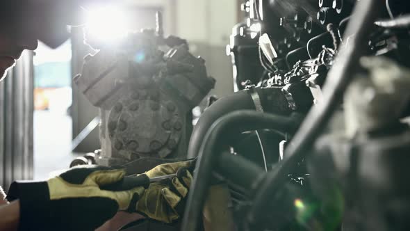 Car Mechanic In Auto Repair Shop Working On Engine.  alt