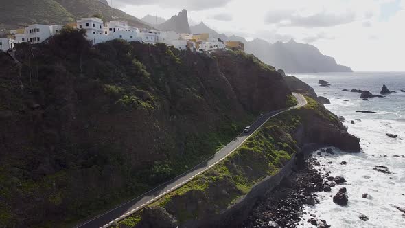 Aerial drone view of a coastal road and a village above it in Benjio, Anaga National Park, Northern alt