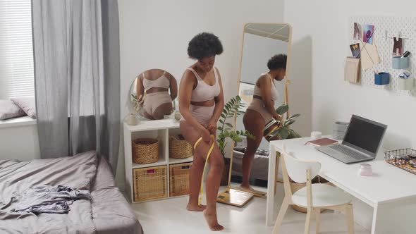 Curvy African American Woman Measuring Her Parameters at Home alt