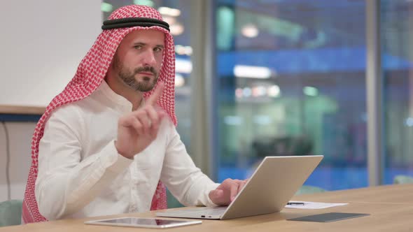 Arab Businessman with Laptop Saying No with Finger Sign alt
