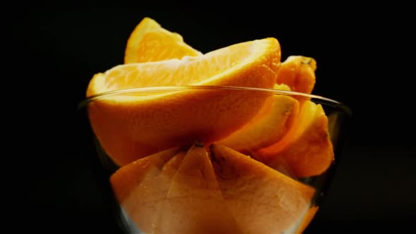 Sweet Orange For Dessert On A Black Background Rotate In A Glass Plate