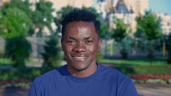 Close Up Smiling Afroamerican Man Looks Camera on Background Park in Summer alt