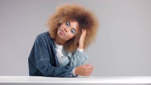 Mixed Race Black Woman with Big Afro Hair in Studio Alone in Denim Shirt
