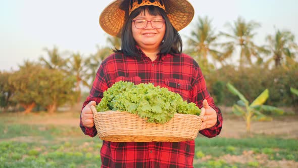A female farmer collects her vegetables and produce in the fields.