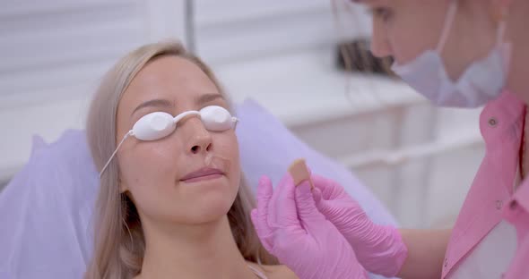 Cosmetologist Applies the Woman a Gel for Laser Hair Removal on Her Upper Lip Cosmetic Procedures in alt