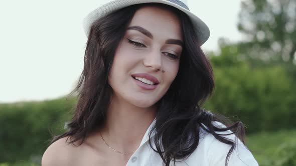 Female Artist Thinks and Corrects Hair with Brush During Painting a Landscape alt