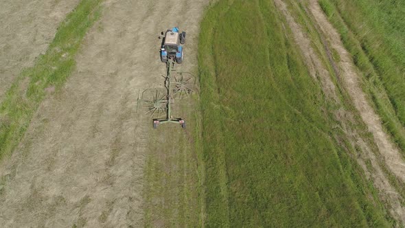 Tractor with Rake Tedders on the Farm Field alt