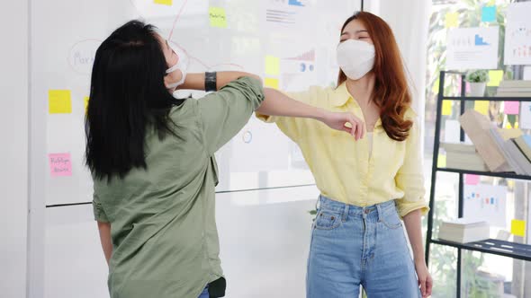Asia greeting with elbow bump and wear medical face mask for social distancing in new normal. alt