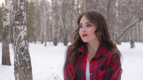 Charming Female with Long Hair Walking in Snowy Forest