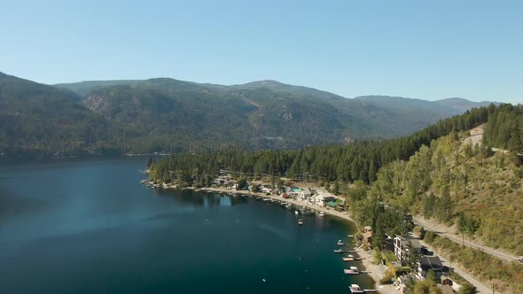Aerial View of a Residential Homes By a Lake and Mountains alt