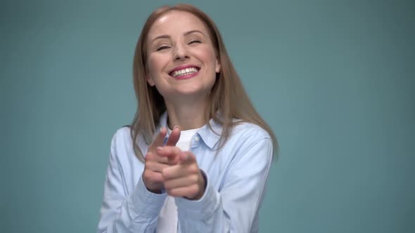 Attractive caucasian girl straight in front of the camera and pointing with flirtatious emotions. alt