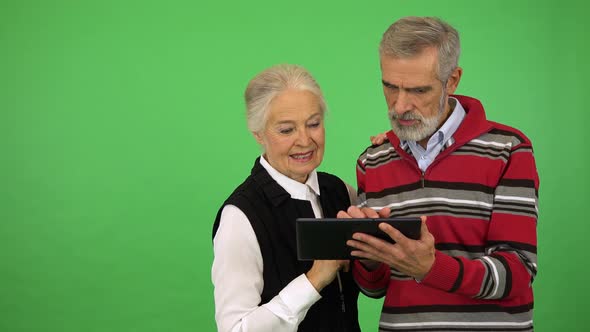 An Elderly Couple Works on a Tablet - Green Screen Studio alt