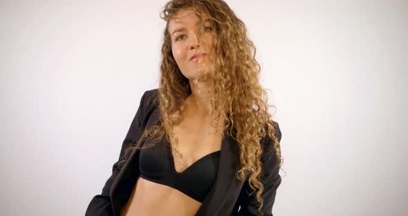 Portrait of a Smiling Curly-haired Girl Who Is in the Studio on a White Background, Wearing a Black alt
