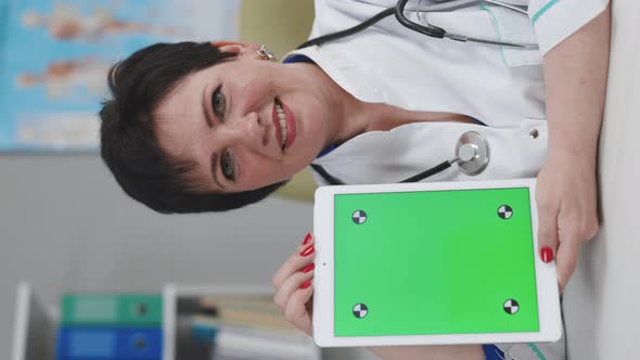 Vertical Video Format of Female Doctor Explain Disease and Medicare with Tablet in Green Screen alt