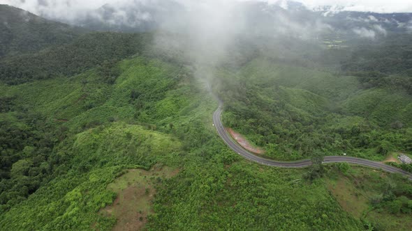 Aerial view of mountain road through tropical forest in countryside of Asia by drone