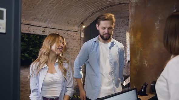 Hospitable Modern Couple Giving their Passports for Registration to the Fiendly Female Manager alt