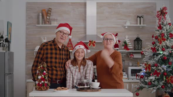 Pov of Happy Family Wearing Santa Hat Greeting Remote Friends During Online Videocall Conference alt
