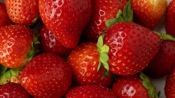 Juicy ripe exotic strawberry rotates on a white background 360. Eco fruits and berries summer.