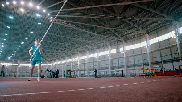Pole Vaulting - Sportsman Is Rising a Long Pole and Running alt