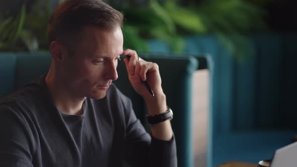 Thoughtful Serious Young Man Student Writer Sit at Home Office Desk with Laptop Thinking of alt