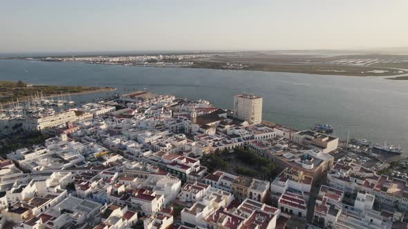 Ayamonte, Spain: Orbiting shot above traditional white buildings on seaside. Aerial View alt